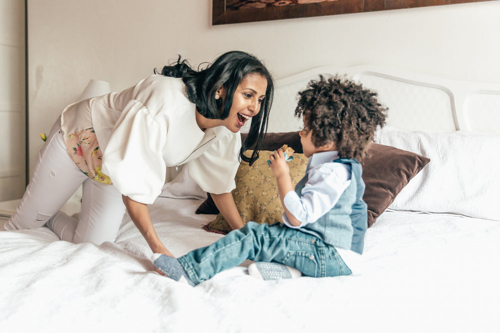mother-playing-with-son-in-bedroom